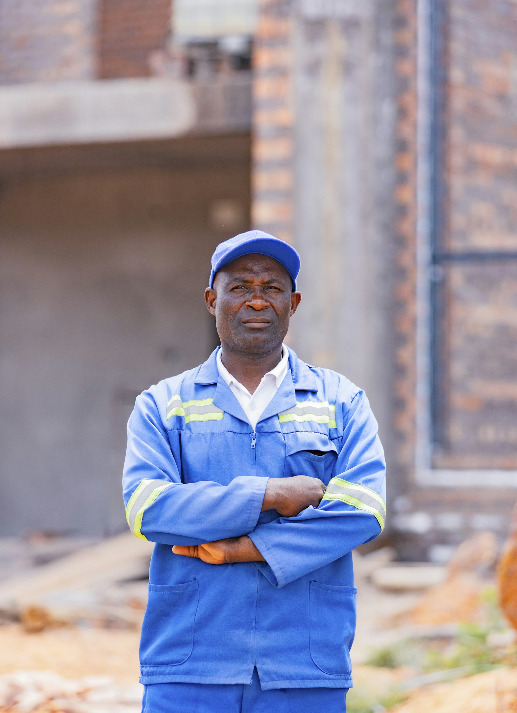 Tradesman standing with arms crossed on a work site